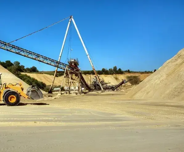 Carrière de granulats avec convoyeur, chargeuse et stocks de sable